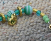 Green & Gold Glass Beaded Bracelet with Nautilus Dangles