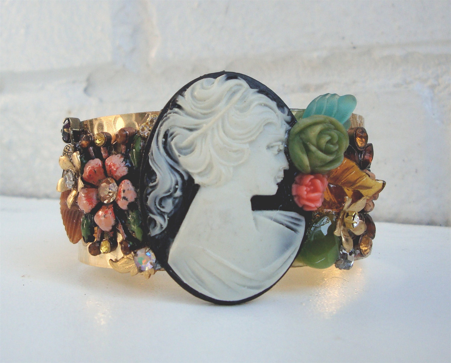 Beautiful and feminine hammered  brass vintage cuff bracelet with big powder black cameo, glass and enamel flowers, leaves and rhinestones