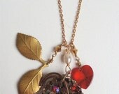 Vintage charm necklace with red Swarovski crystal heart, leaf spray charm & a 1940's recycled brooch  as focal point.