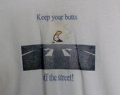 Short sleeved t-shirt that says "Keep your butts off the street"