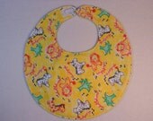 Baby bib, four soft layers, reversible, yellow with red lions and zebras.