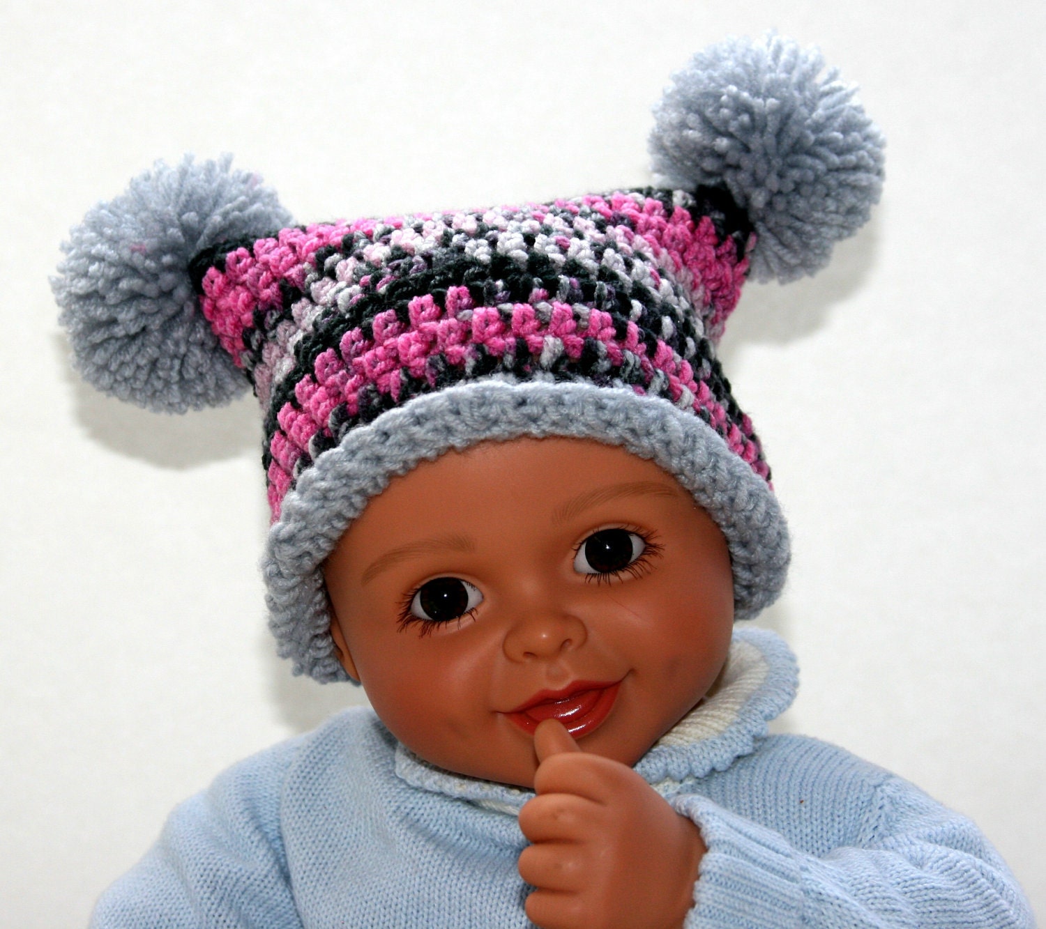 Baby Girl hat jester pom crocheted in grey, pink and black camo with gray pom poms. Newborn to 3 months