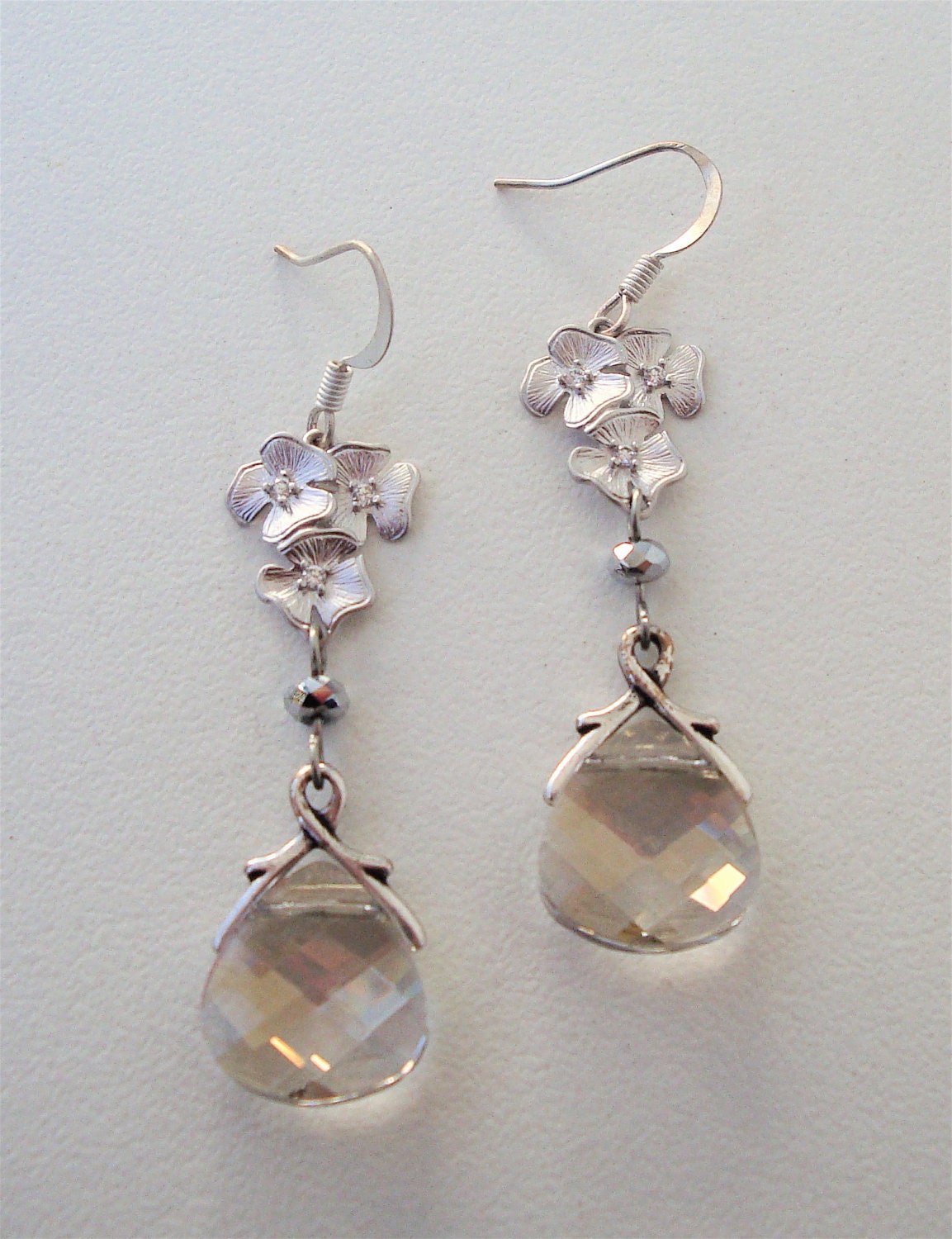 Matte silver cluster of azalea's with tiny cz's and a beautiful silver shade swarovski crystal briolette with french ear wire