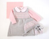 A knitted baby dress in gray with jacquard for a little baby girl