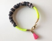Neon yellow fabric wrapped bracelet with pink tassel