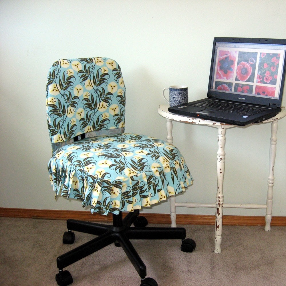 Picture of a handmade Office Chair Slip Cover on an office chair, for sale www.etsy.com, the chair is in front of a small table with a lpatop and a mug on it, representing a home office