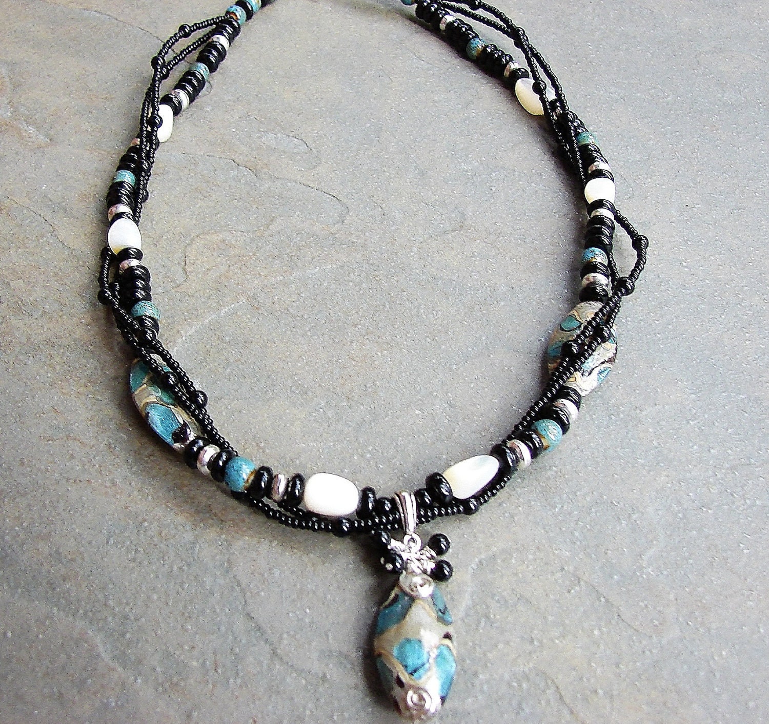 black, blue, white and silver twisted three strand glass bead necklace with hand wrapped pendant