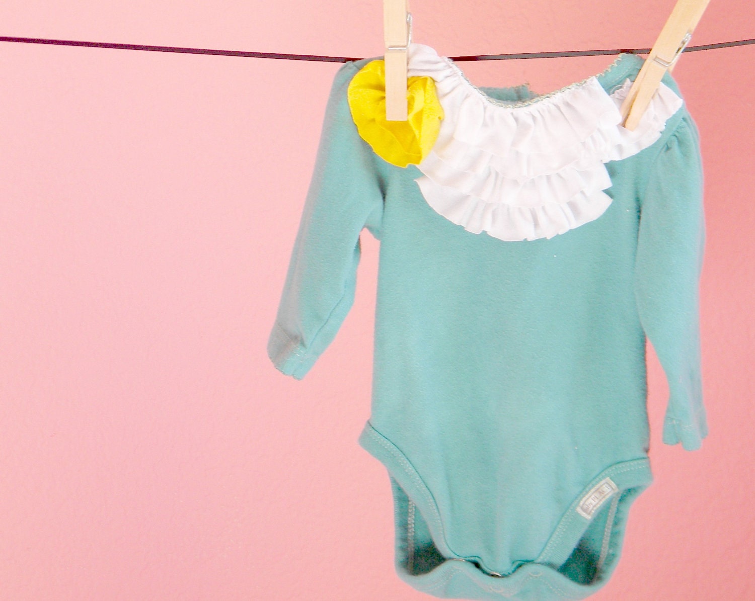 teal baby onesie with white ruffles yellow flower and long sleeves in size 9 months