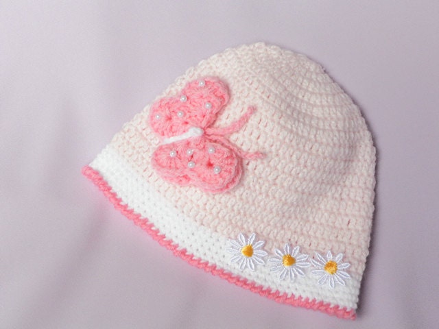 کلاه Crocheted برای یک نوزاد در صورتی نرم را با یک پروانه زیبا
