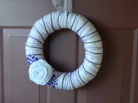 Purple and white yarn wreath with felt flower