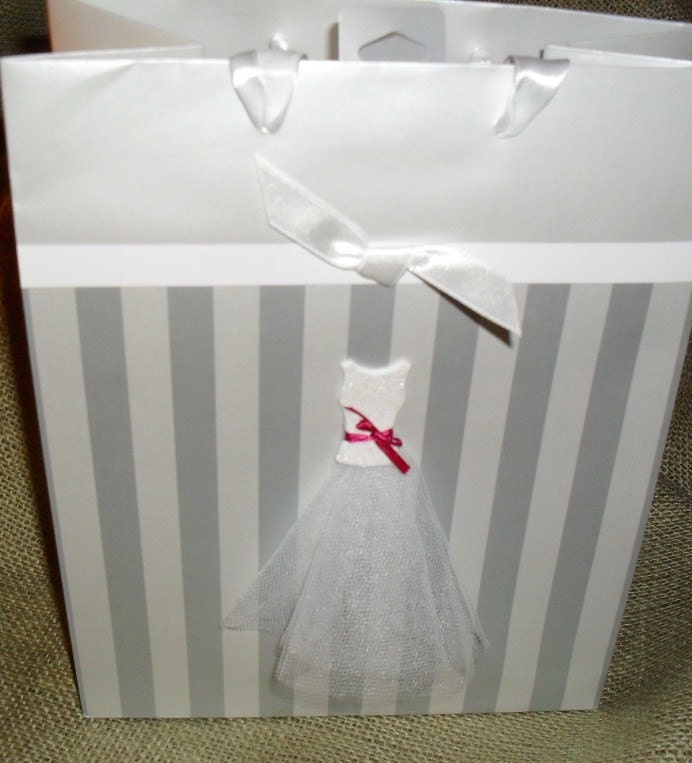 This silver striped gift bag features a wedding dress with a white glitter