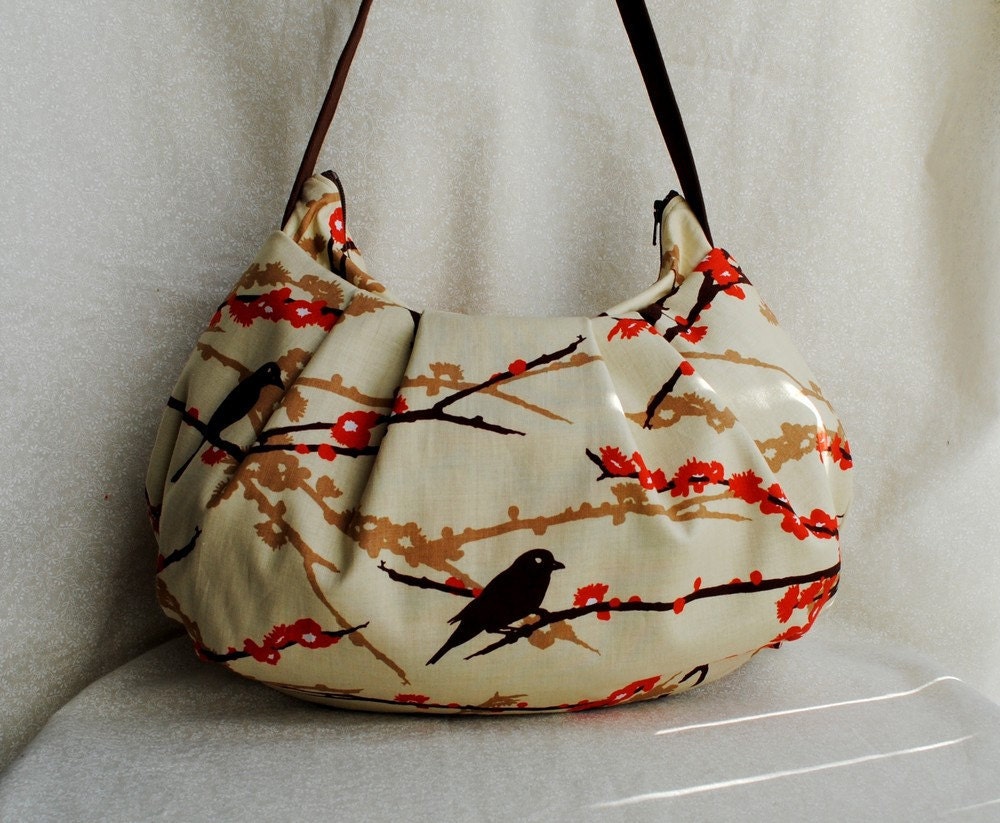 Cream-colored purse with cherry branches and black birds