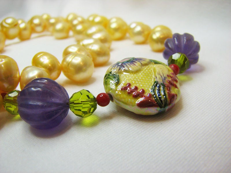 Yellow pearl necklace with floral bead in purple green and tangerine