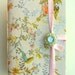 Handmade journal / notebook made with floral colorful & silver fabric opens with crystal embedded green enamel button and pink satin ribbon