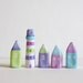 Little village with 4 pastel little clay houses and a striped lighthouse