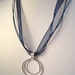 double circle argentium sterling silver 930 hammered organic pendant on blue ribbon