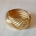 Faux gold cuff style bracelet bangle with spring opening shiny goldtone vintage