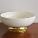 Large white ceramic bowl with brass footed base