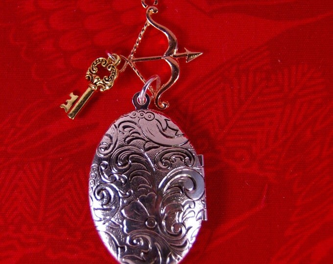 Elongated Floral Decorated Silver-tone Locket with Archery and Key Charms