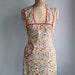 vintage 1940s bib apron / red trim, mustard, scarlet and olive floral vines on white / the FRICASEE apron