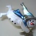 Flying Snowman with blue patterned stocking cap and bluescarf holding a star pin brooch