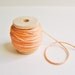 Peach cotton bakers twine trim on a wood Spool -15 yards