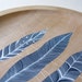 patterned feathers // handpainted design on a sycamore wood plate for UK homes and gardens magazine // by natasha newton