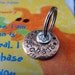 The Daisy Pet Tag 5/8 inch with a small sterling silver tag