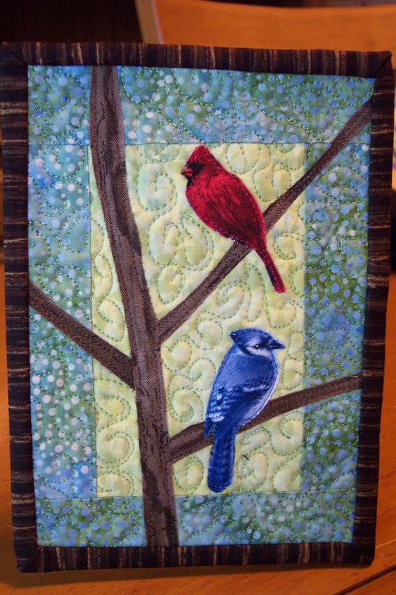 Cardinal and Blue Jay on Branches Art Quilt displays on easel