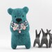 A turquoise blue felted bear brooch