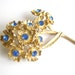 Vintage antiqued brass bouquet brooch with royal blue rhinestones