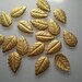 18 tiny brass leaf charms