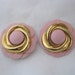 Pair of pale pink leather flower shaped shoe clips with shiny gold tone metal accents