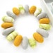 18 felted wool pebbles / beads (light gray, golden yellow, green/white marble)