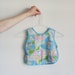 mother goose bib smock . story time pastel baby wear .sale s a l e .disaster relief