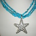 Star fish necklace with triple strand Aqua Blue mother of peal.