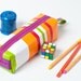A colorful and playful striped pencil case with orange, green and red stripes