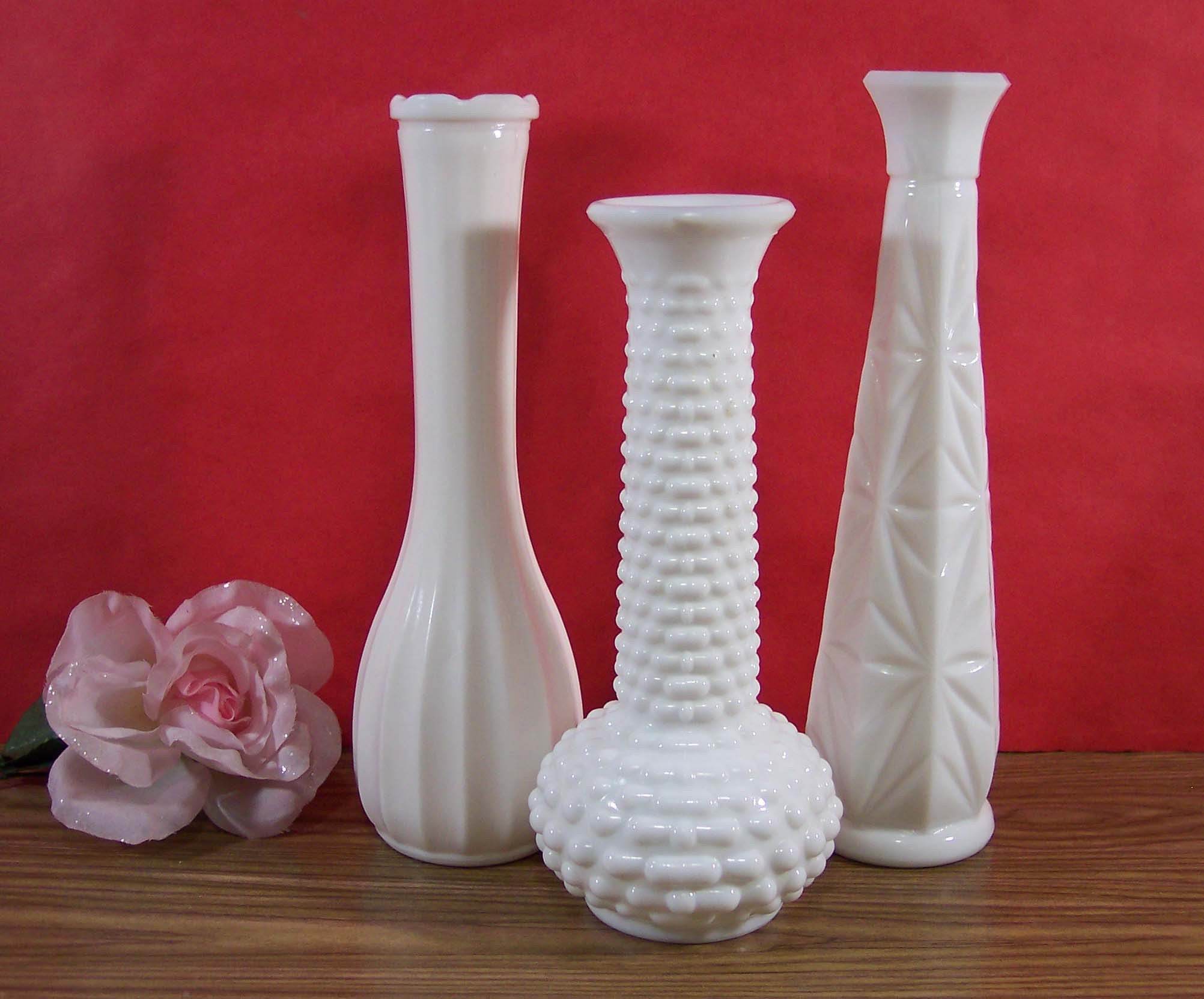 THREE MILK GLASS BUD VASES. ONE E.O. BRODY ONE C L G CO. ONE