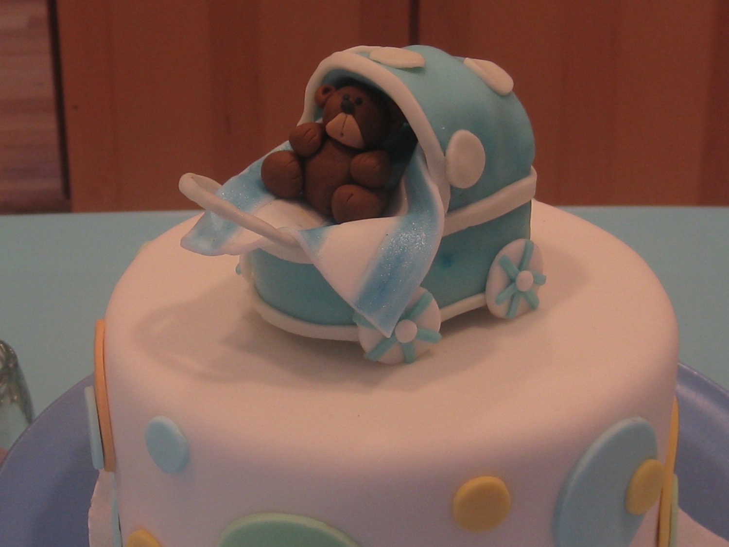 Edible fondant blue baby stroller/carriage cake topper.