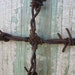 barbed wire cross on wood door