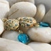Jambo - lampwork glass dangle earrings in blues, greens, and creams with brass accents