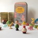 Toy set in a tin, pocket size amusement kit for kids, with vintage Sevi figures, wood Monopoly houses, and other random items