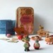 Toy set in a tin, pocket size amusement kit for kids, with vintage Sevi figures, wooden game pieces, and other random items