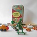 Toy set in a tin, skateboarding dude with random and vintage items, a travel game kit for quiet imaginative play