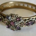 Antique Victorian or Edwardian gilt filigree hinged bangle with amethyst glass stones