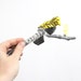 A little bird told me - sculpture on gray yarn wrapped branch in lemon yellow, black, white, and emerald green