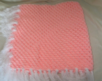 a crocheted pink shawl/blanket