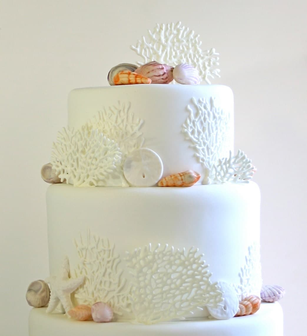 Pretty white beach wedding cake with edible coral Pretty white beach wedding cake with edible coral