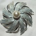 Vintage Sarah Cov silver tone pinwheel brooch with faux pearl center