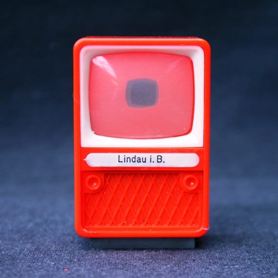 What is on telly tonight. Vintage red toy TV viewer. Souvenir